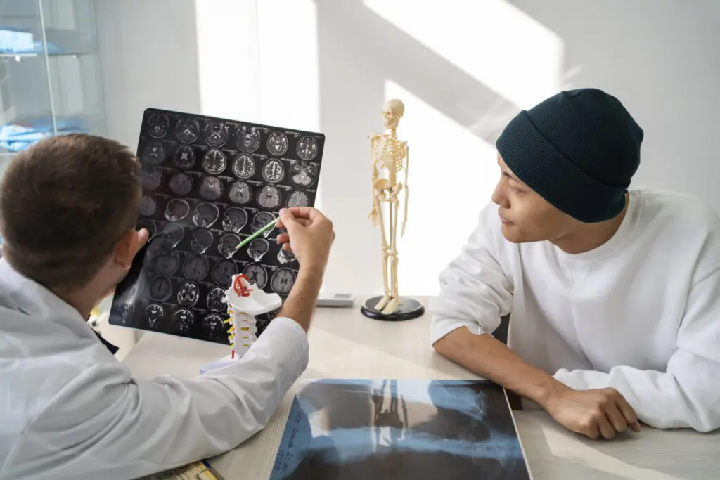Doctor explaining brain scan to patient during neurological rehabilitation consultation at Punarvaas Hospital Bangalore